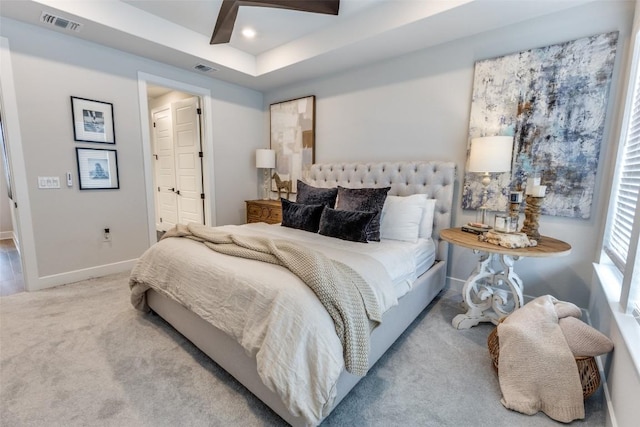 carpeted bedroom with visible vents, beamed ceiling, ensuite bath, and baseboards