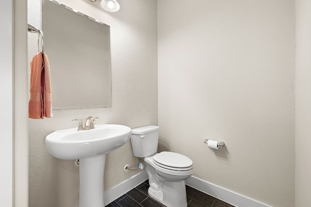 1050 Kenney Fort Xing Unit 24, Round Rock, TX 78665 - half bath featuring baseboards, toilet, wood finish floors, and a sink