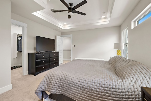 bedroom featuring carpet flooring, visible vents, a raised ceiling, and baseboards