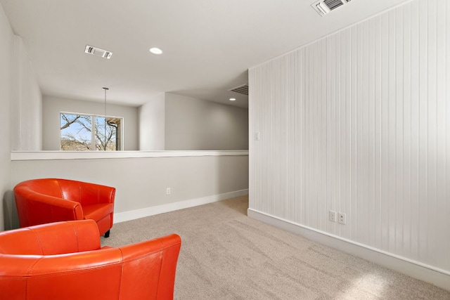 living area with visible vents, carpet floors, and baseboards