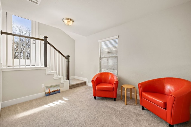 living area featuring baseboards, stairs, carpet, and vaulted ceiling