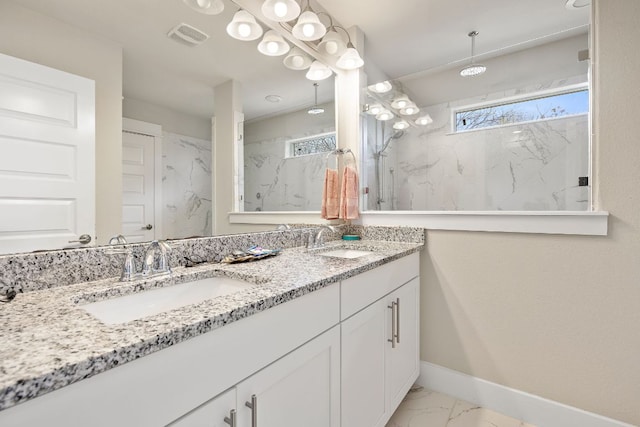 full bath with plenty of natural light, marble finish floor, and a sink