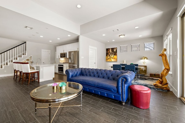 living room with recessed lighting, visible vents, and wood tiled floor