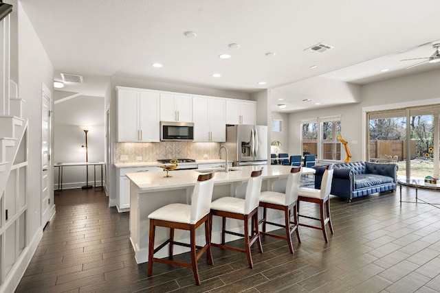 kitchen featuring a sink, stainless steel appliances, backsplash, and visible vents