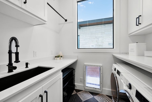 laundry area featuring a sink, baseboards, cabinet space, and washer and dryer