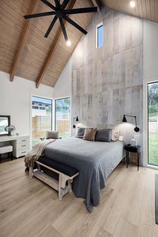 bedroom with beamed ceiling, wood finished floors, and high vaulted ceiling