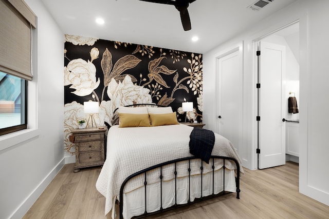 bedroom featuring visible vents, an accent wall, baseboards, recessed lighting, and wood finished floors