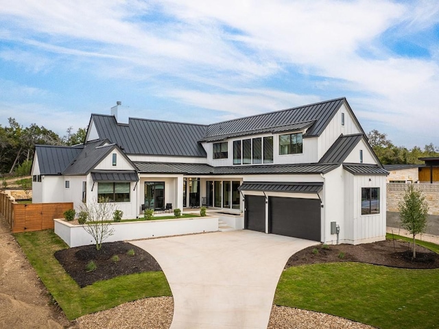 modern inspired farmhouse featuring fence, concrete driveway, metal roof, a garage, and a standing seam roof