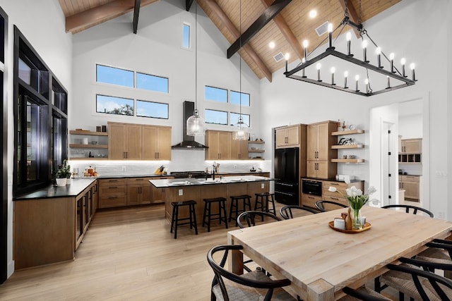 dining room with light wood-style flooring, beam ceiling, visible vents, and wooden ceiling