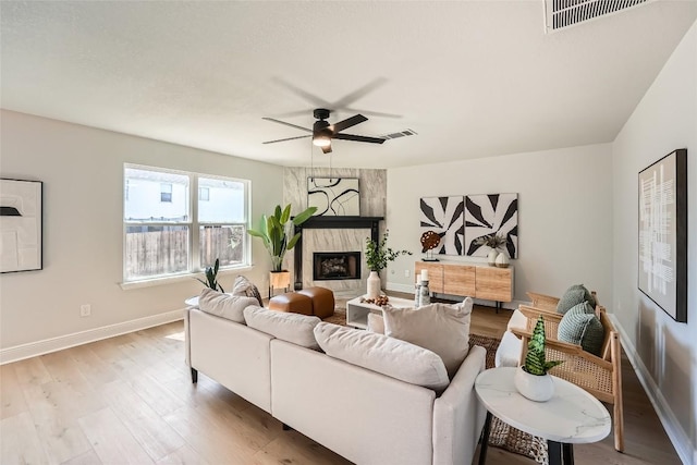 living area featuring visible vents, light wood-style floors, and ceiling fan