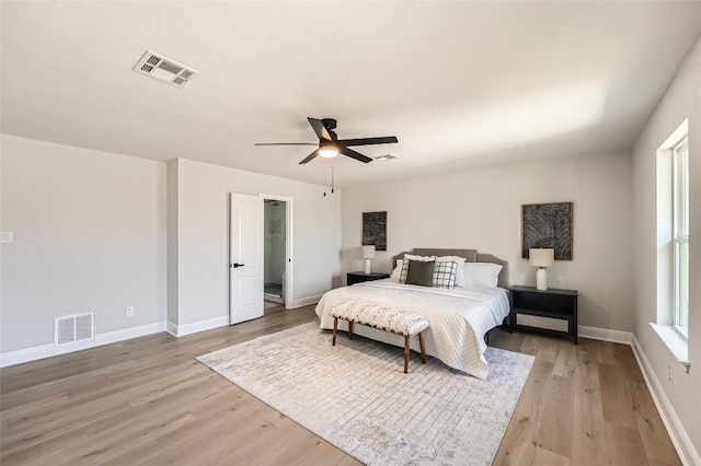 bedroom with baseboards, visible vents, and light wood finished floors