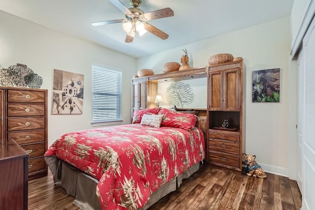 bedroom featuring dark wood finished floors, baseboards, a closet, and a ceiling fan