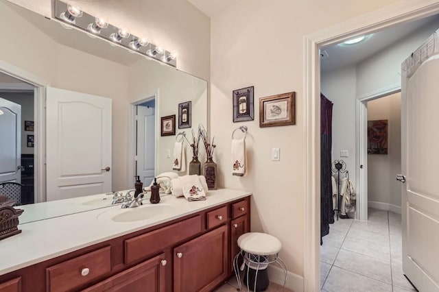 bathroom with tile patterned floors, vanity, and baseboards