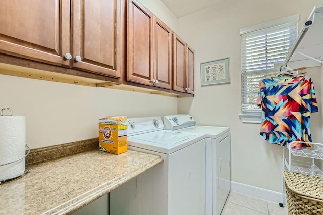 laundry room with baseboards, cabinet space, separate washer and dryer, and light tile patterned flooring