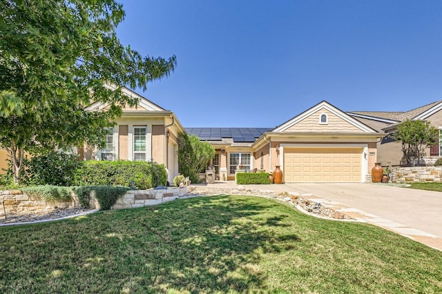 ranch-style home featuring stucco siding, concrete driveway, a front lawn, a garage, and roof mounted solar panels