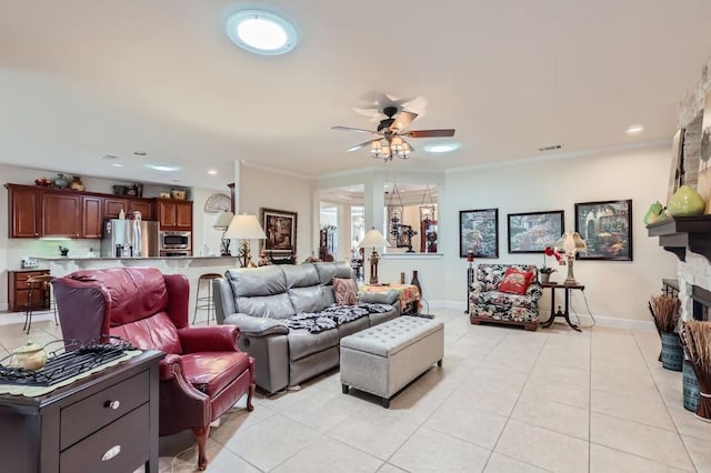 living room with visible vents, a ceiling fan, light tile patterned flooring, crown molding, and baseboards