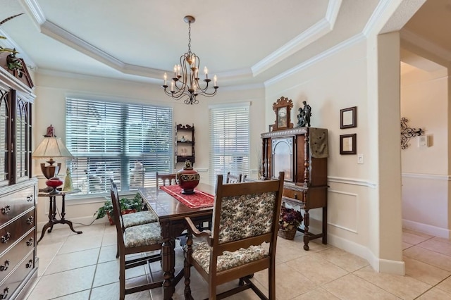 dining room featuring an inviting chandelier, a tray ceiling, light tile patterned floors, and crown molding