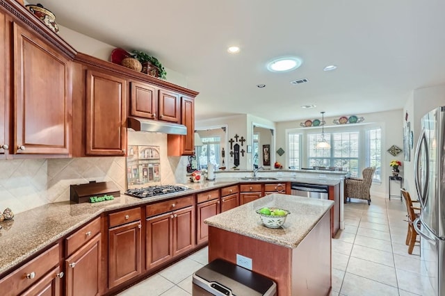 kitchen with visible vents, backsplash, under cabinet range hood, a peninsula, and stainless steel appliances