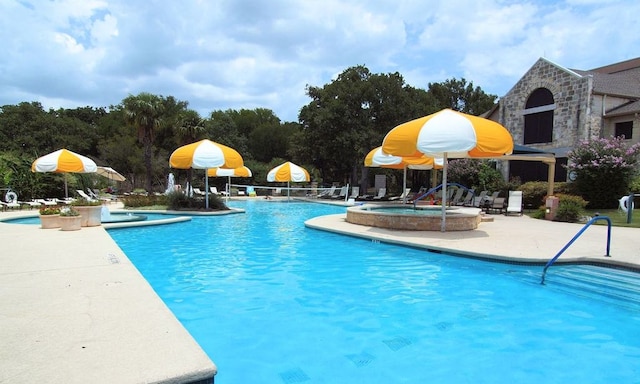 community pool featuring a patio area and a hot tub