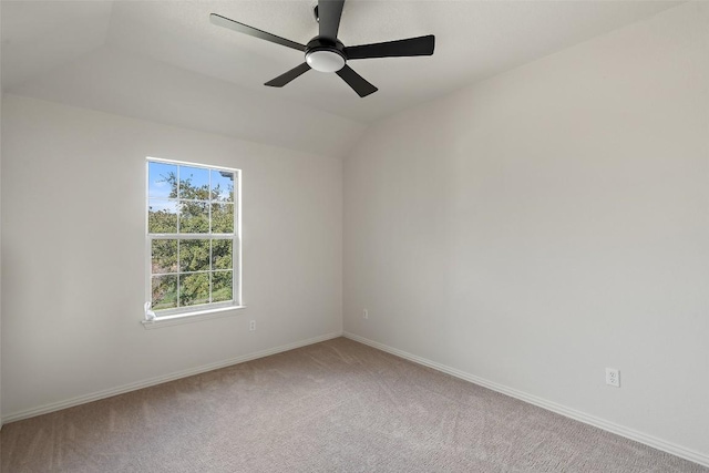 empty room featuring a ceiling fan, lofted ceiling, light colored carpet, and baseboards