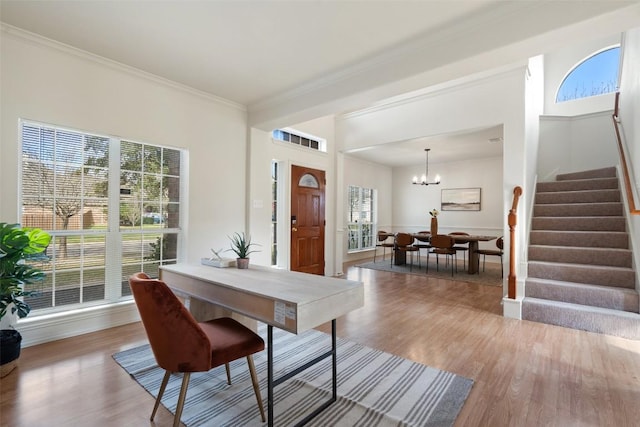 dining room featuring stairway, crown molding, an inviting chandelier, and wood finished floors