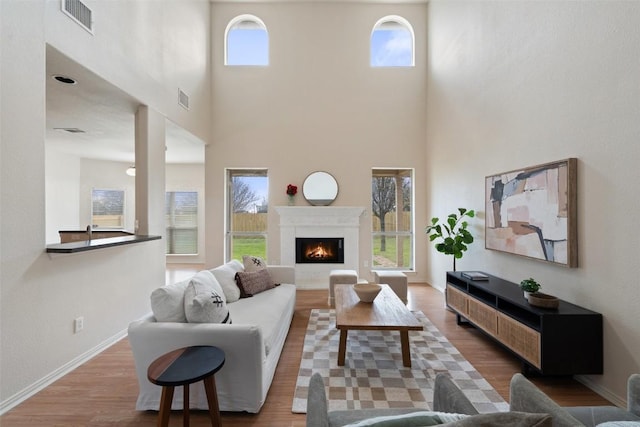 living area featuring visible vents, a healthy amount of sunlight, and wood finished floors