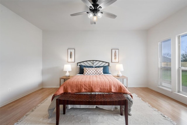 bedroom featuring ceiling fan, light wood-type flooring, and baseboards