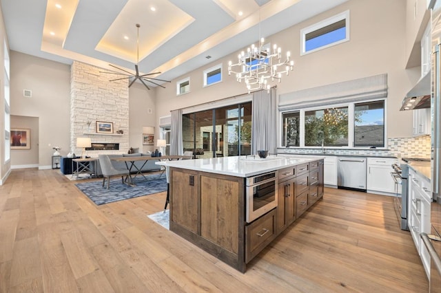 316 Duckhorn Pass, Austin, TX 78738 - kitchen featuring appliances with stainless steel finishes, a high ceiling, a chandelier, light wood finished floors, and a kitchen island