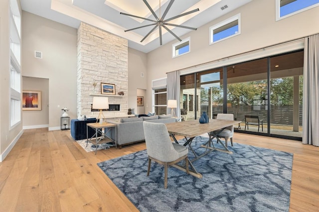316 Duckhorn Pass, Austin, TX 78738 - dining space featuring a towering ceiling, a stone fireplace, and wood-type flooring