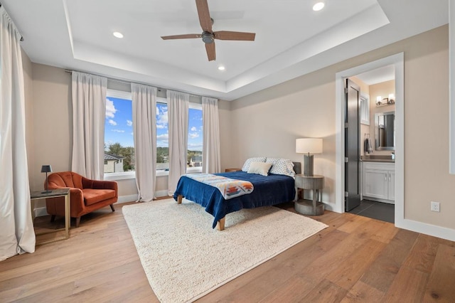 316 Duckhorn Pass, Austin, TX 78738 - bedroom with a raised ceiling, light wood finished floors, recessed lighting, ensuite bathroom, and a ceiling fan