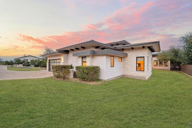 316 Duckhorn Pass, Austin, TX 78738 - view of front facade featuring concrete driveway, a lawn, stone siding, an attached garage, and stucco siding