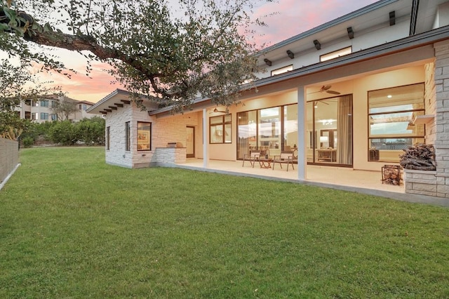 316 Duckhorn Pass, Austin, TX 78738 - back of house at dusk featuring a patio, a lawn, and a ceiling fan