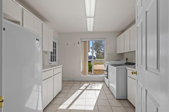 25048 River Rd, Spicewood, TX 78669 - laundry room with washing machine and dryer, cabinet space, and light tile patterned floors