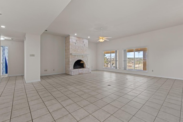 25048 River Rd, Spicewood, TX 78669 - unfurnished living room featuring ceiling fan, light tile patterned flooring, recessed lighting, and a stone fireplace