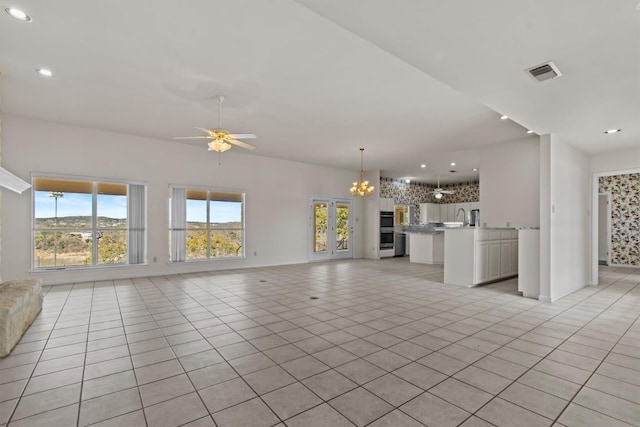 25048 River Rd, Spicewood, TX 78669 - unfurnished living room featuring light tile patterned floors, a ceiling fan, recessed lighting, and a chandelier