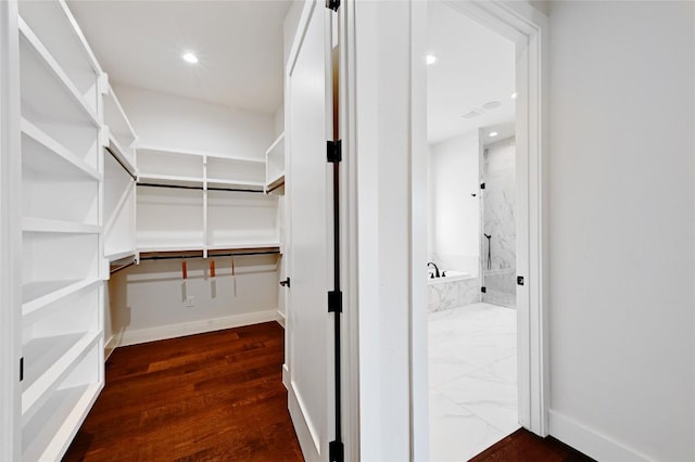 spacious closet with dark wood finished floors