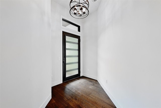 foyer with baseboards, an inviting chandelier, and dark wood-style flooring