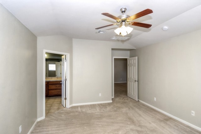 unfurnished bedroom with lofted ceiling, light colored carpet, visible vents, and baseboards