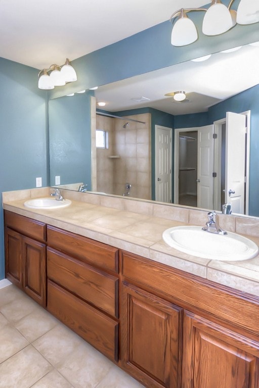 full bath featuring tile patterned flooring, double vanity, and a sink