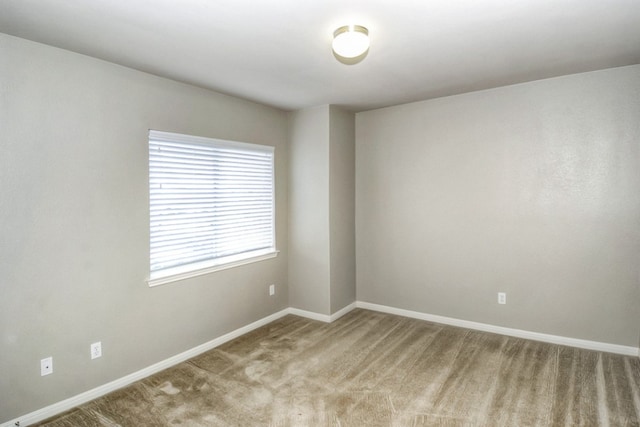 carpeted spare room with baseboards