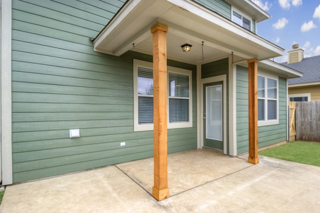 entrance to property with a patio area and fence