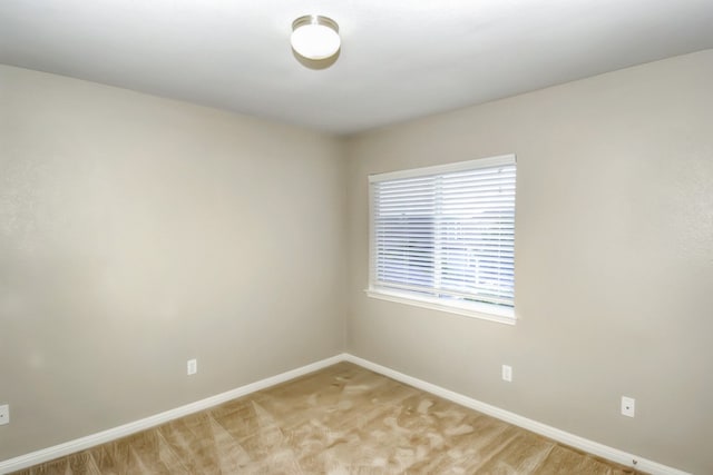 empty room with light colored carpet and baseboards