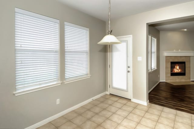 interior space featuring light tile patterned floors, baseboards, and a tile fireplace