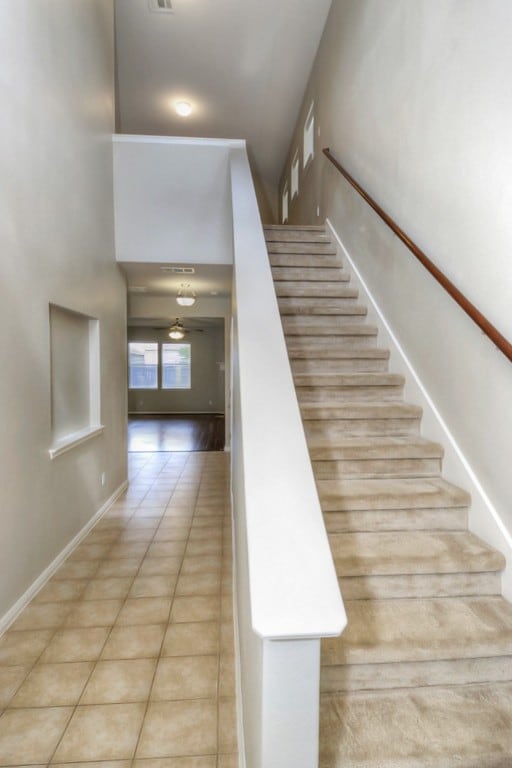 stairs featuring tile patterned floors and baseboards