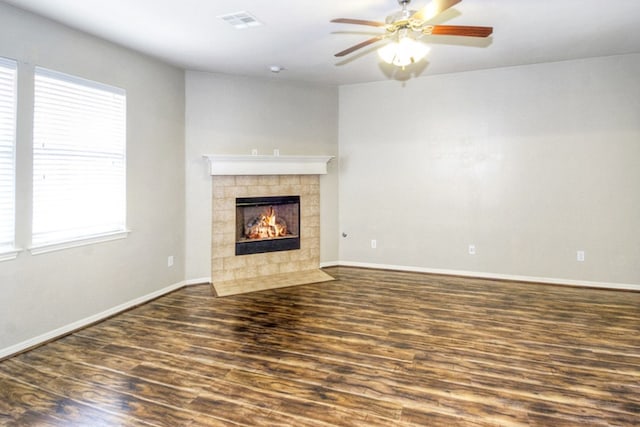 unfurnished living room featuring visible vents, a fireplace, baseboards, and wood finished floors