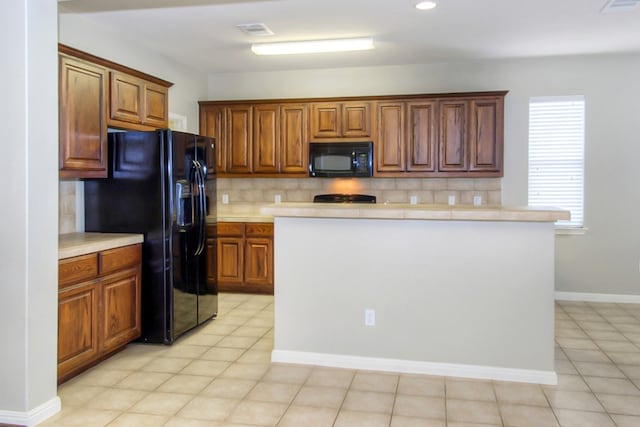 kitchen with backsplash, black appliances, brown cabinetry, and light countertops