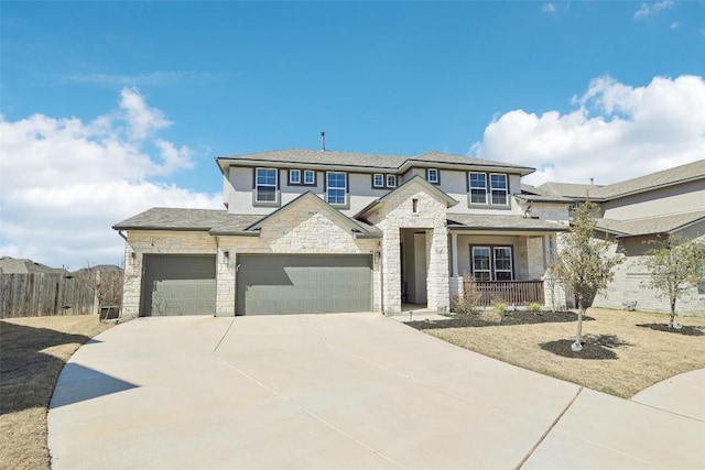 view of front of house with fence, covered porch, stucco siding, stone siding, and driveway