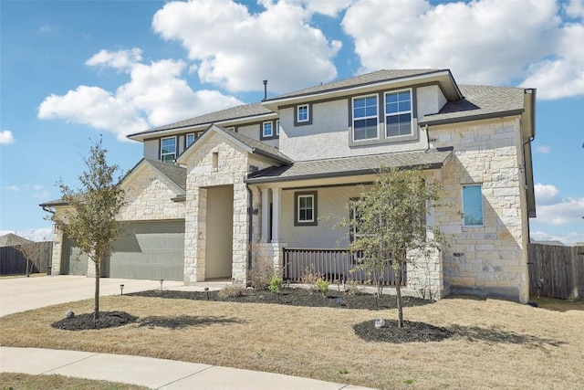 view of front of property featuring stucco siding, stone siding, fence, covered porch, and an attached garage