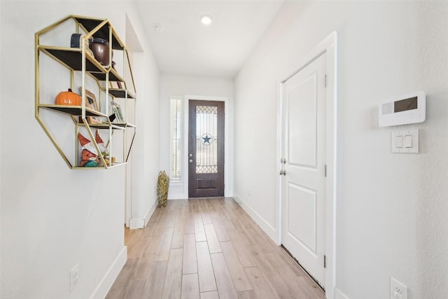 foyer entrance with light wood-type flooring and baseboards