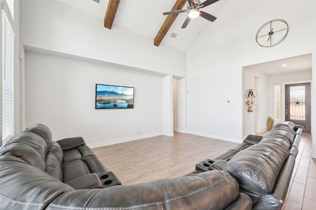 living area featuring visible vents, beamed ceiling, wood finished floors, high vaulted ceiling, and a ceiling fan